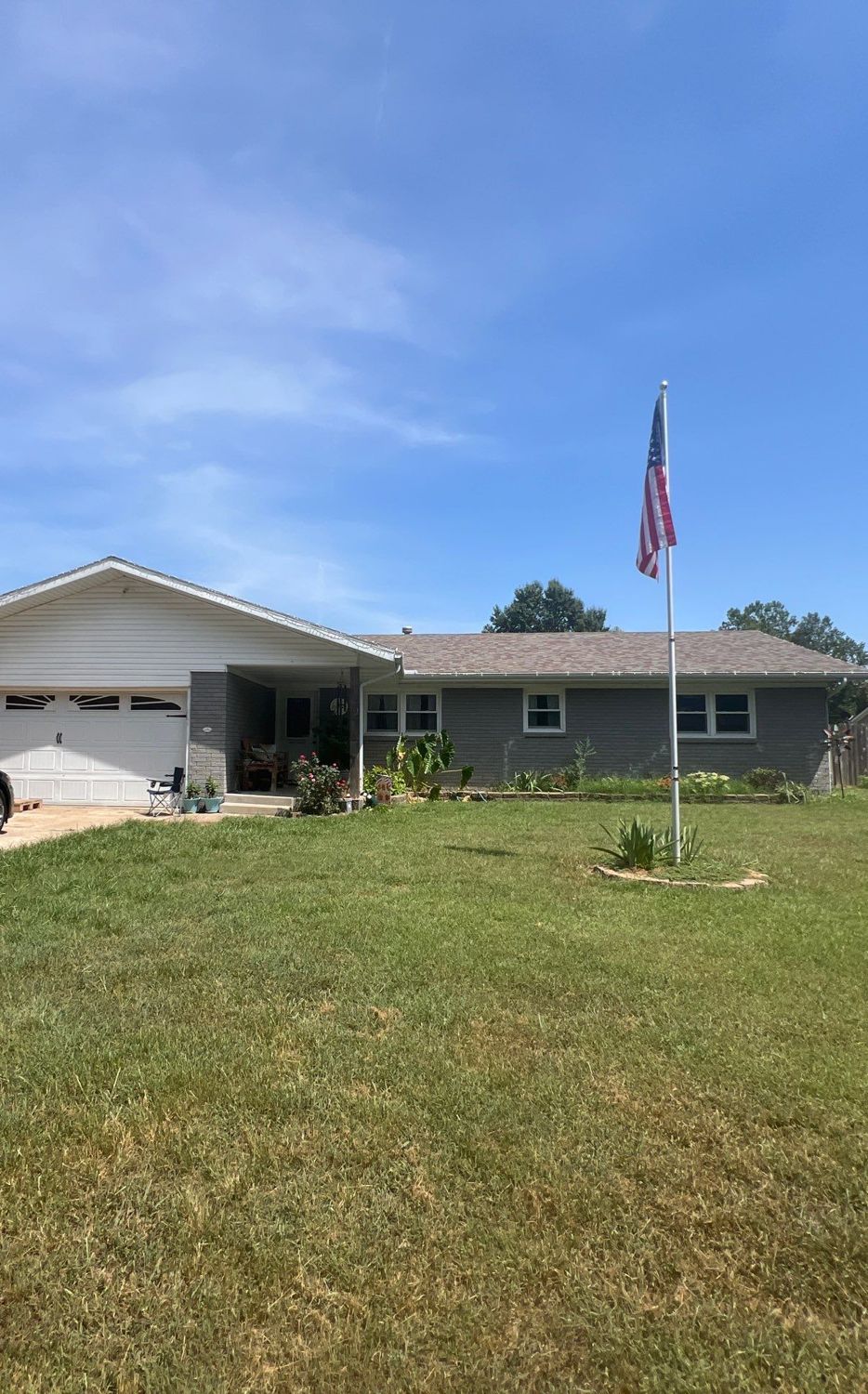 Ranch home in the Ozarks with new roof and gutters by Nixa Roof Co